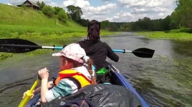 Family kayak trip. Mom and daughter rowing a boat on the river, a water hike, a summer adventure. Eco-friendly and extreme tourism, active and healthy lifestyle