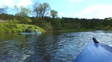 Family kayak trip. An elderly married couple with a grandson rowing a boat on the river, a water hike, a summer adventure. Age-related sports, mental youth and health, tourism, active old age