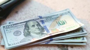 El, 100 dolarlık banknotu yığının içine koyar ve bir banknot alır. Nakit para, 100 dolarlık banknotlar. Finans, ekonomi, mali planlama, ekonomi, tasarruflar.