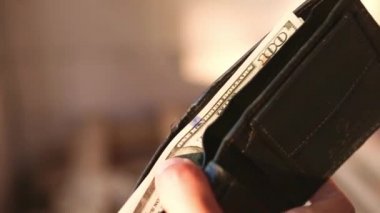 El, 100 dolarlık banknotu yığının içine koyar ve bir banknot alır. Nakit para, 100 dolarlık banknotlar. Finans, ekonomi, mali planlama, ekonomi, tasarruflar.