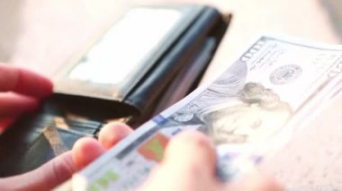 El, 100 dolarlık banknotu yığının içine koyar ve bir banknot alır. Nakit para, 100 dolarlık banknotlar. Finans, ekonomi, mali planlama, ekonomi, tasarruflar.
