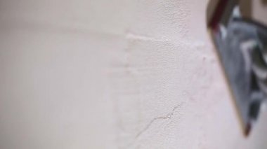 Sanding of walls with sandpaper after treatment with dry building mixes with plaster and putty before painting. The surface alignment is smooth. Home renovation with your own hands