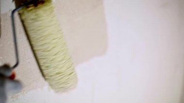 Applying a liquid primer coating a construction roller is preparation for finishing the walls of a house made of porous blocks. Primer for painting, treatment with dry building mixes. Repair