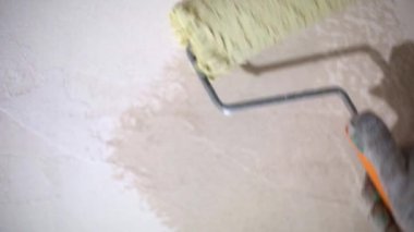 Applying a liquid primer coating a construction roller is preparation for finishing the walls of a house made of porous blocks. Primer for painting, treatment with dry building mixes. Repair