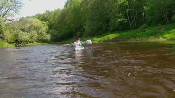 家族のカヤック旅行 川にボートを漕ぐ孫を持つ高齢者の夫婦 水のハイキング 夏の冒険 年齢関連スポーツ 精神的な若者と健康 アクティブな高齢者 — ストック動画