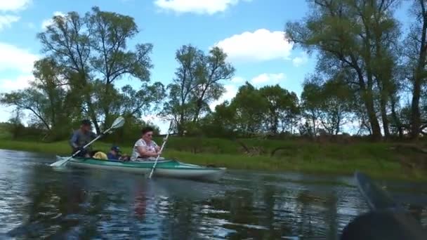 家族のカヤック旅行 川にボートを漕ぐ孫を持つ高齢者の夫婦 水のハイキング 夏の冒険 アクティブな高齢者 ロシア カルーガ 2021年夏 — ストック動画