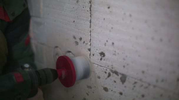 電力ソケット用多孔質ブロックの壁に穴を開ける パンチのある男が家の中に電気配線を設置する — ストック動画