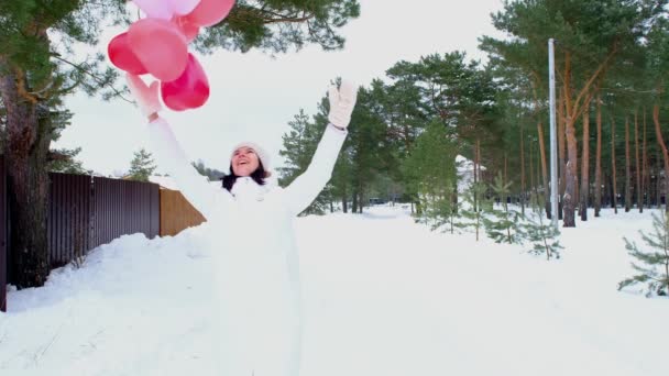 Glückliche Frau Wirft Herzförmige Luftballons Winter Mit Schnee Nach Draußen — Stockvideo