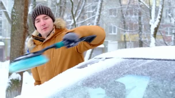 Een Man Poetst Sneeuw Uit Een Auto Een Sneeuwval Een — Stockvideo