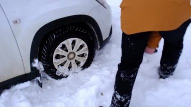 Adam araba küreğiyle bozuk arabayı karla kazıp çıkarıyor. Kışın bir kar yağışı sonrası nakliye aracı bir kar yığınına sıkıştı, dibe oturdu. İlk yardım, çekici, kış lastikleri dikenleri ve tüm sezon boyunca. Yavaş çekim 