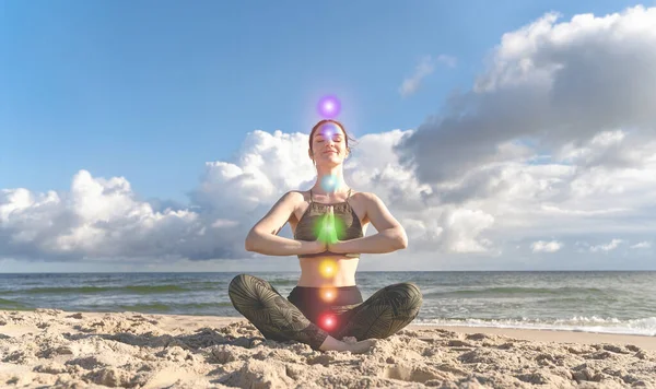 Yedi çakra. Lotus pozisyonundaki bir kadın kumsalda meditasyon yapıyor. Kendini iyileştirme, kendini tanıma kavramı