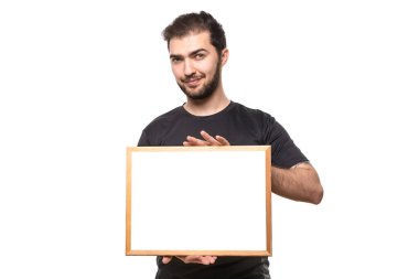 Yüz ifadesi olan adam poster gösteriyor. Mesajın ya da ilanın için yer aç. Stüdyodaki siyah tişörtlü adam.