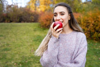 Açık havada elmalı mutlu kız. Meyveli genç bir kadın. Sağlık, bakım, çiğ gıda diyeti