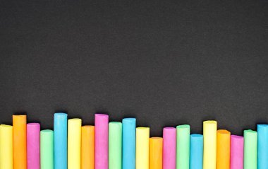 Colored chalk on black background. Education concept. Back to school. Space for your text