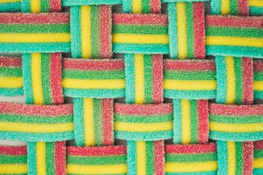 Marmalade wicker stripes. Colorful rainbow background. Sugar gummy surface close up