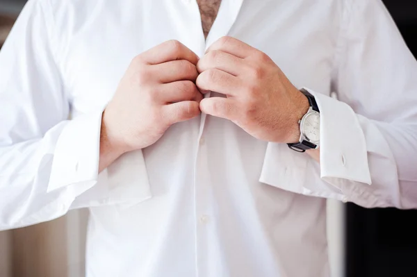 Groom preparing for the wedding ceremony buttoning his shirt — Stock Photo, Image