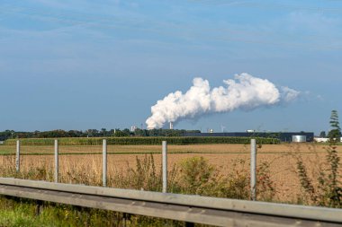 Bir enerji santralinin soğutma kulesinden çıkan beyaz su buharı bulutları.