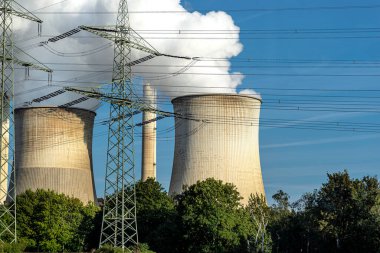 Bir enerji santralinin soğutma kulesinden çıkan beyaz su buharı bulutları.