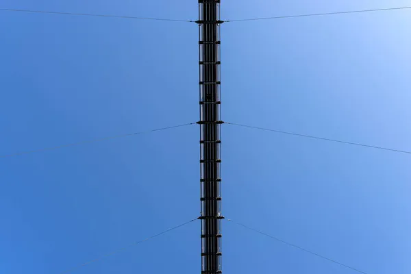 下から青い空に向かって鉄のロープで吊られた木製の橋 — ストック写真