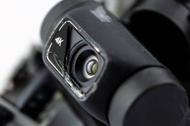 Kırık kabloyla düşmüş hasarlı bir İHA 'nın beyaz arka planda izole edilmiş 4k lenslerinin makro görüntüsü..
