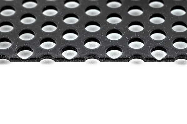Makroaufnahme Einer Schwarzen Metalloberfläche Mit Runden Löchern Und Weißen Punkten — Stockfoto