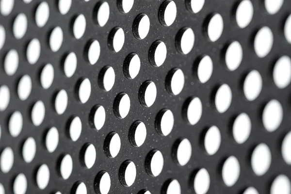 Yuvarlak Delikli Beyaz Noktalı Siyah Metal Bir Yüzeyin Beyaz Arka — Stok fotoğraf