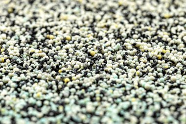 Filtrenin içinde aktif karbon ve su filtreleme incileri bulunan makro bir fotoğraftan yapılmış arkaplan, merkezde seçici bir odak.