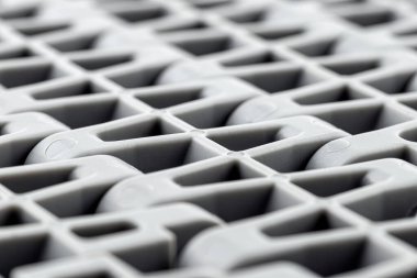 Plastik bir taşıma bandının makro fotoğrafından yapılmış arkaplan bölümler halinde birleştirilmiş, merkezde seçici odak.