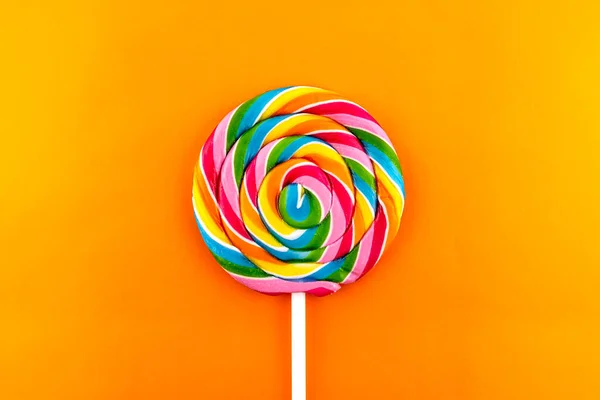 Sweet Spiral Shaped Colorful Lollipop Lying Center Isolated Orange Background — Stock Photo, Image
