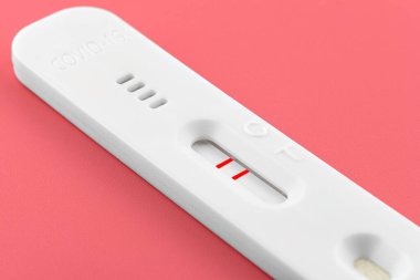 Geniz dokusu için koronavirüs pozitif antijen testi. Pembe arka planda, kırpma yolu ile izole edilmiş..