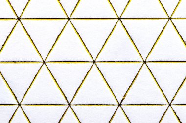 Beyaz kağıda işlenmiş altın elmas ve üçgen şekilli çizgiler, üst görünüm.
