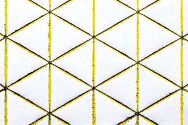 Beyaz kağıda işlenmiş altın elmas ve üçgen şekilli çizgiler, üst görünüm.