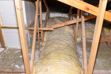 Glass wool placed on pipes in domestic ventilation with heat recovery, pipes placed on a roof truss.