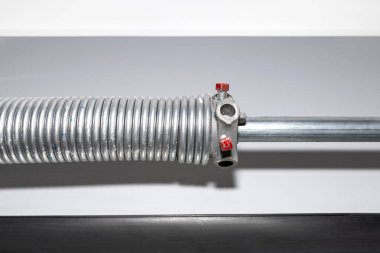 Springs tensioning the garage door mechanism, visible blue spring and spring head.