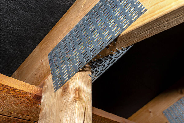 Barbed tile connecting the roof structure covered with a membrane on a single-family house, view from the inside.