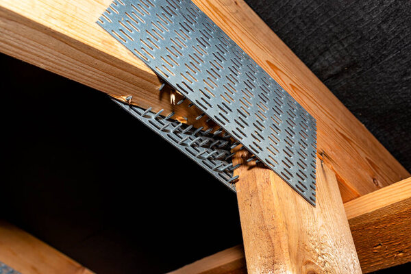 Barbed tile connecting the roof structure covered with a membrane on a single-family house, view from the inside.