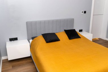 Hardallı yatak örtüsü olan modern bir yatak odası, basit bir görünüm..
