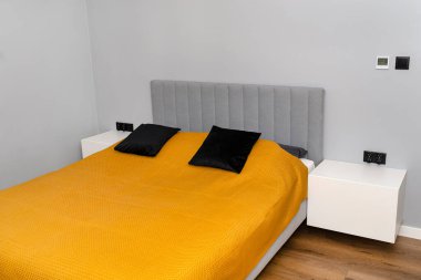 Hardallı yatak örtüsü olan modern bir yatak odası, basit bir görünüm..