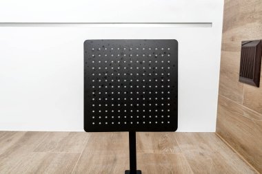 Modern bir duşta aşağıdan görülen büyük bir yağmur, görünür bir havalandırma ızgarası..