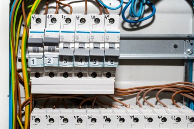 Kapalı ve ON pozisyonunda tek fazlı sigortalar, ev sigorta kutusuna yerleştirilmiş, görünür elektrik kabloları.