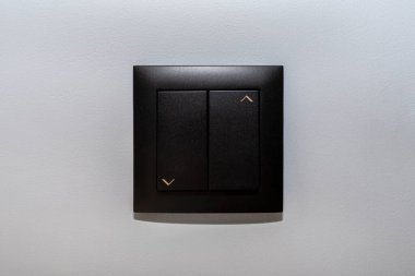 Siyah çerçeve ve paten panjurunun düğmesi evdeki gri duvarda yukarı ve aşağı..