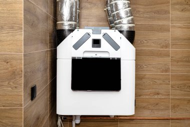 Modern bir gaz kazan dairesinde duvarda asılı duran ısı giderici ile ev mekanik havalandırma. Kahverengi seramik fayanslar ahşabı taklit ediyor..