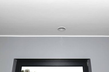 İçerideki mekanik havalandırma, ısı giderici, odanın tavanında patlayan bir anemostat, gri duvar..