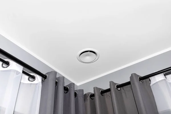 İçerideki mekanik havalandırma, ısı giderici, odanın tavanında patlayan bir anemostat, gri duvar.