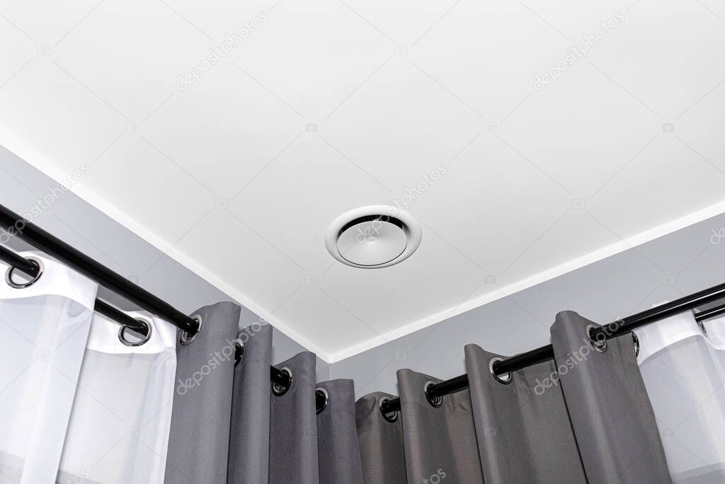 Domestic mechanical ventilation with heat recovery, a visible blowing anemostat on the ceiling in the room, gray wall