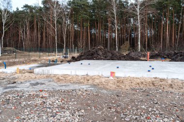 Demir parmaklıklardan ve lağım borularından yapılmış beton tabaka görünür..