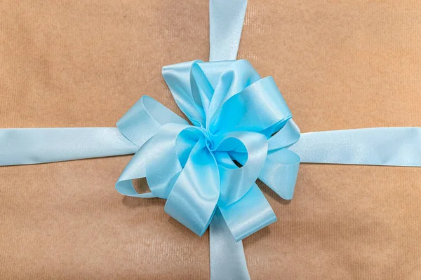 Egy Ajándék Szürke Papírba Csomagolva Kék Szalaggal Masnival Megkötözve Közelről — Stock Fotó