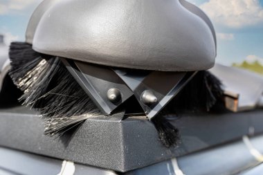 Antrakit seramik fayansla kaplı tek kişilik bir evin çatısındaki fayans sırtta görünür bir şekilde duruyor..