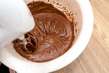 Hamuru çırpıcıyla karıştırıp eritilmiş tereyağıyla karıştırınca hamur kalın bir sıvı kahverengi kütle haline geliyor..