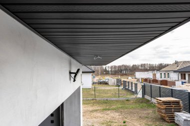 Çağdaş grafit çatı kaplaması kirişlere, görünür kablolara ve LED ışıkları için deliklere bağlıdır.